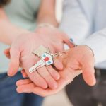 mani che mostrano una chiave di casa