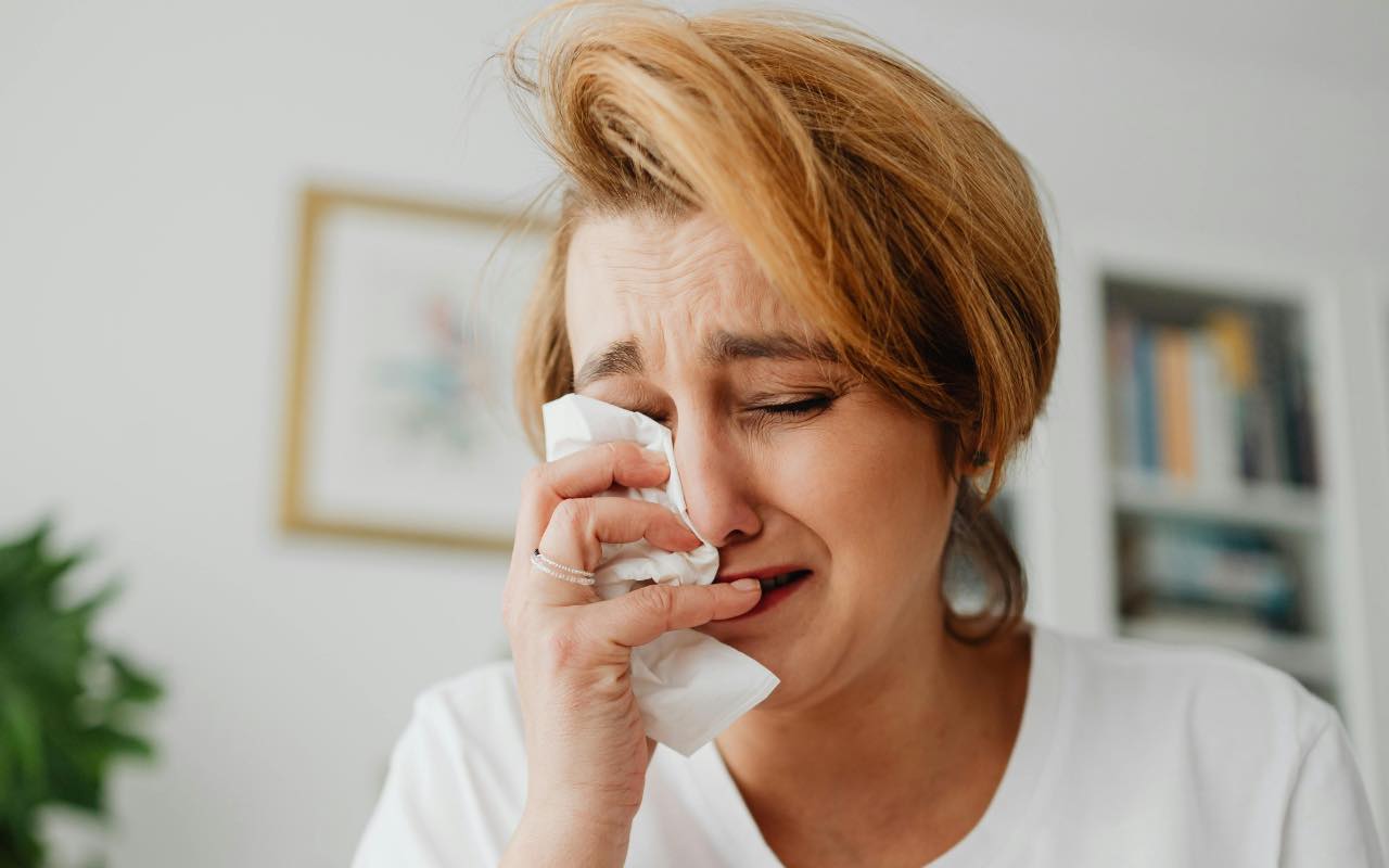 donna che piange e si asciuga le lacrime con fazzoletto
