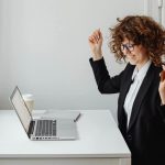 donna che esulta davanti al pc