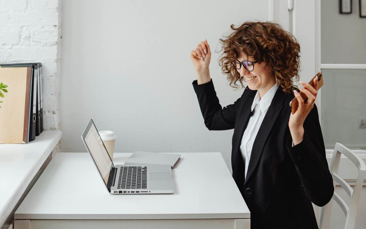 donna che esulta davanti al pc